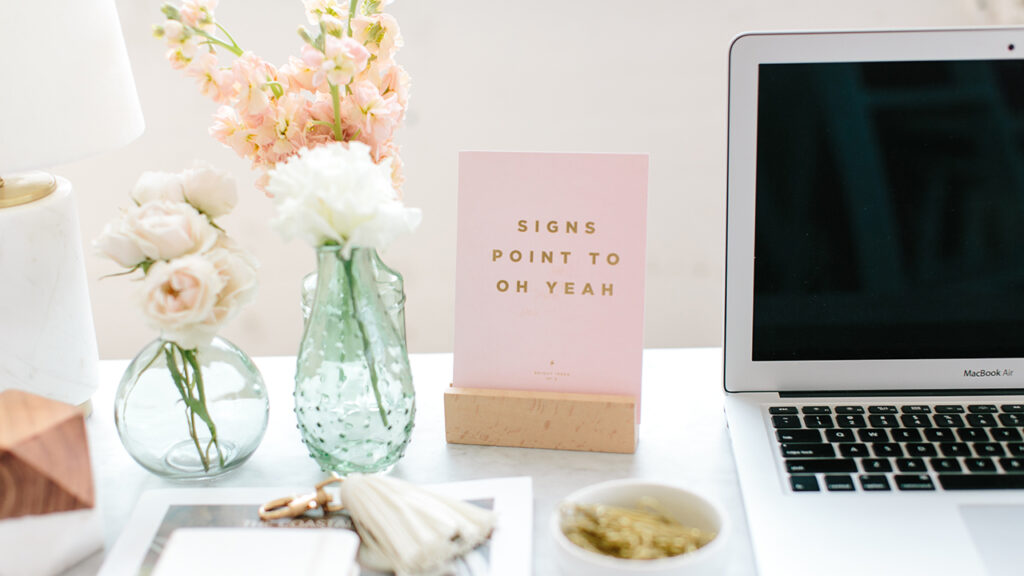 MacBook Air on desk with pastel floral desk accents