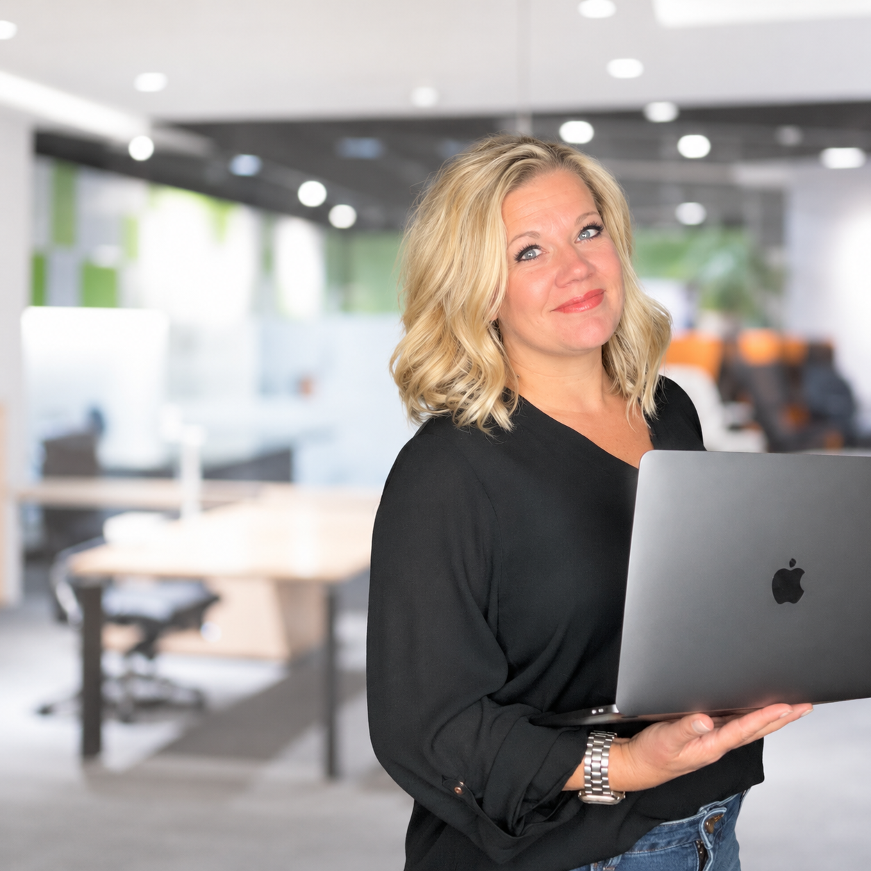Mary standing in front of an office holding a laptop, embodying the essence of creating authentic, stress-free content that resonates with the target audience.