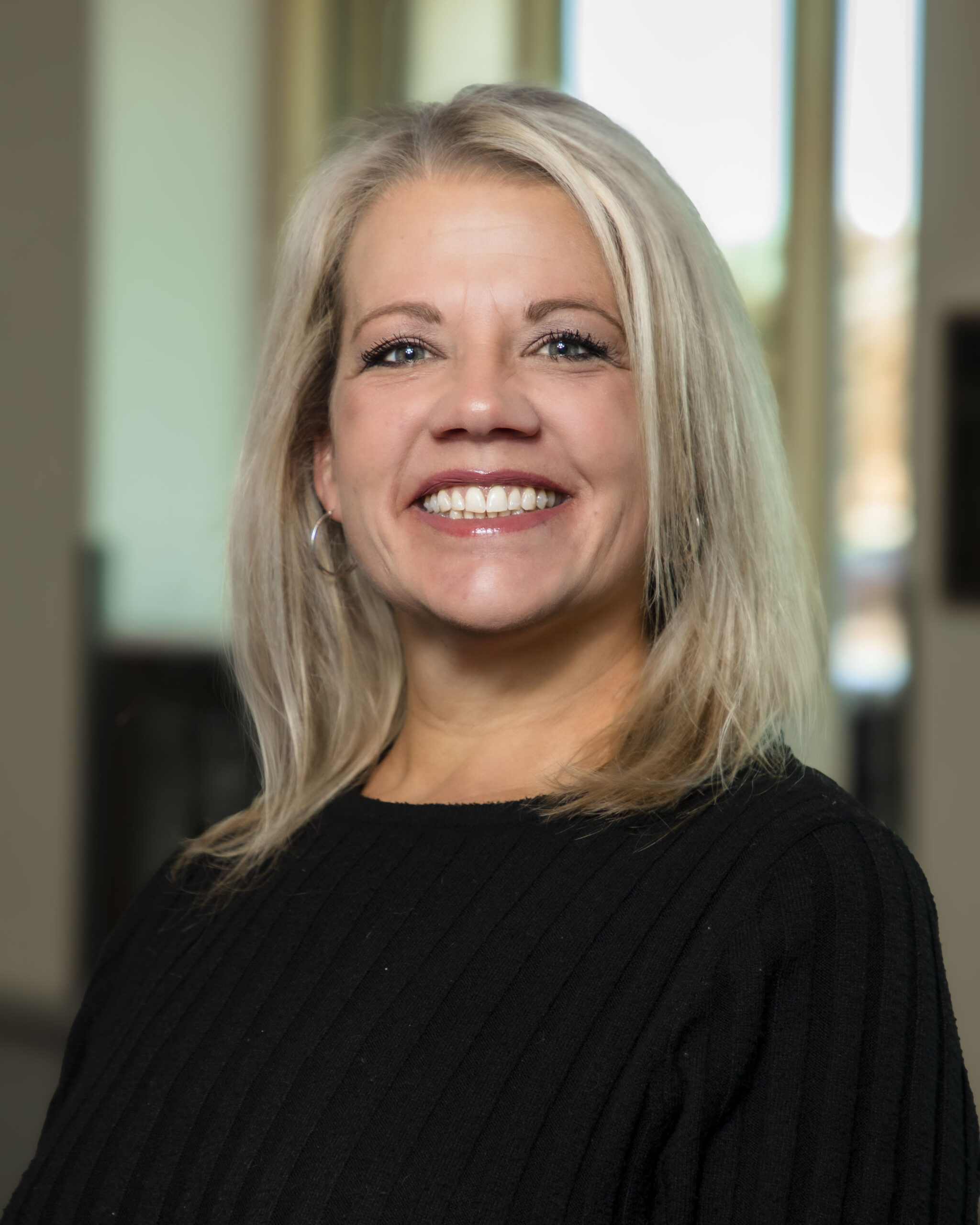 Professional headshot of Mary Moore, a smiling woman with blonde hair wearing a black shirt.